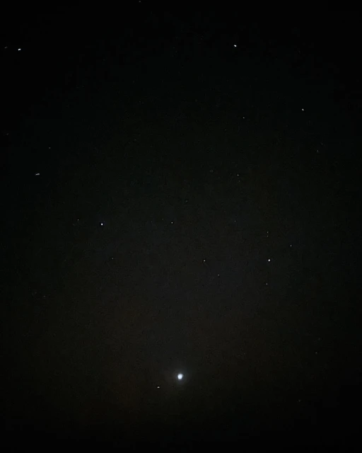 Night sky featuring numerous stars and planets visible against a dark, cloudless backdrop.