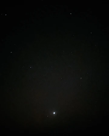Night sky featuring numerous stars and planets visible against a dark, cloudless backdrop.
