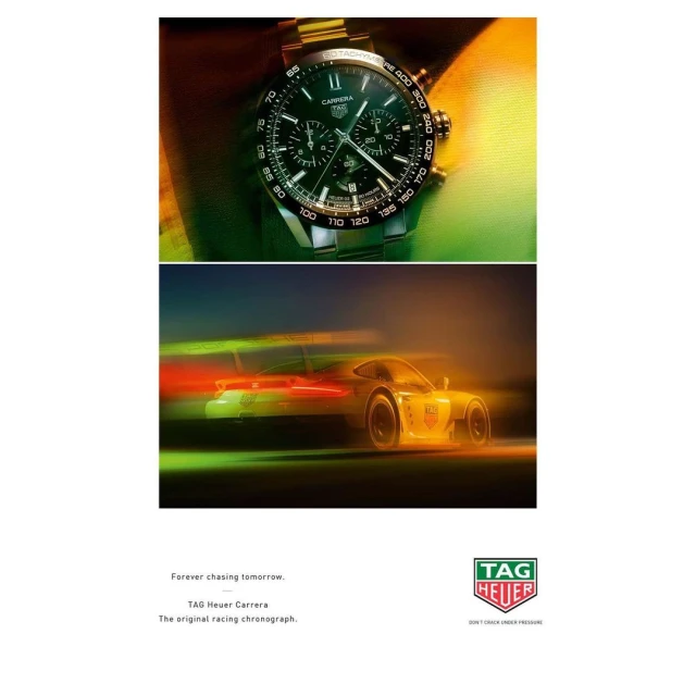 Gold TAG Heuer Carrera watch on a wrist above a blurred race car in motion, showcasing a blend of luxury and automotive speed.