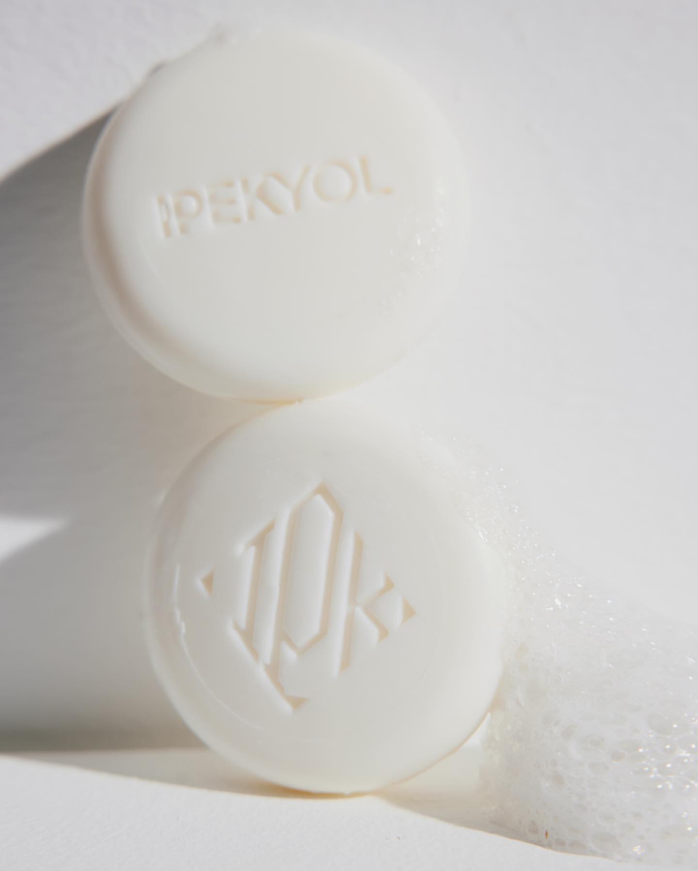 Two round bars of soap are stacked on top of each other, with the brand name IPEKYOL and a logo visible on the soap.