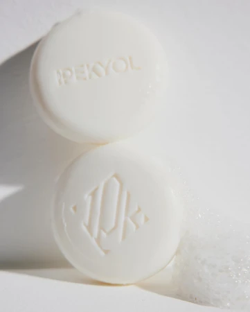 Two round bars of soap are stacked on top of each other, with the brand name IPEKYOL and a logo visible on the soap.