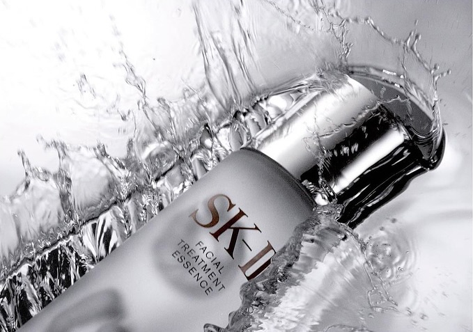 SK-II facial treatment essence bottle in water splash, capturing skincare beauty with fresh, clean and luxurious essence.