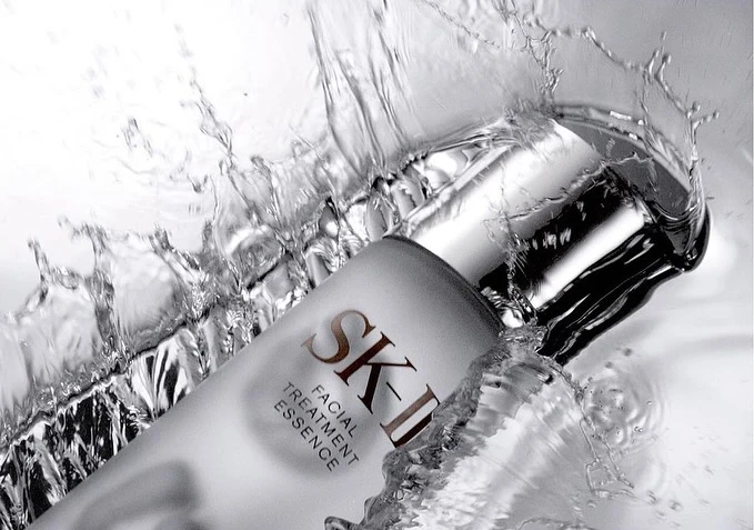 SK-II facial treatment essence bottle in water splash, capturing skincare beauty with fresh, clean and luxurious essence.