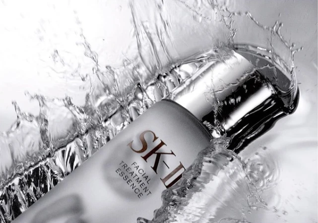 SK-II facial treatment essence bottle in water splash, capturing skincare beauty with fresh, clean and luxurious essence.