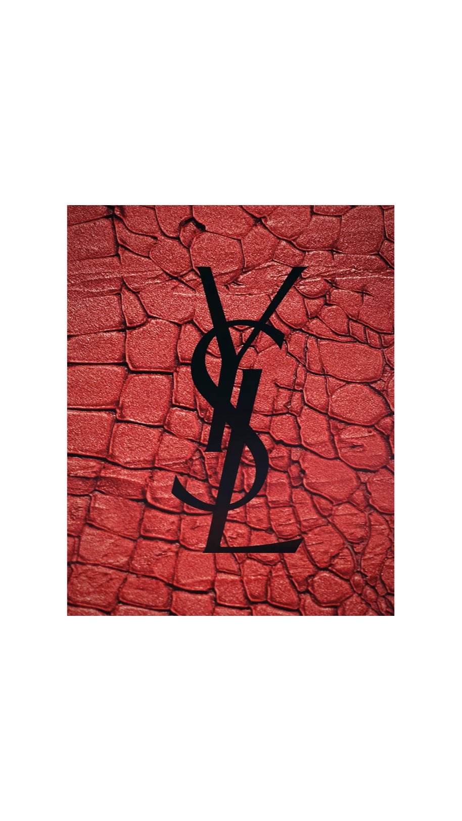 Graphic art featuring a YSL logo in black over a textured red background resembling reptile skin, design, fashion, and logo elements.