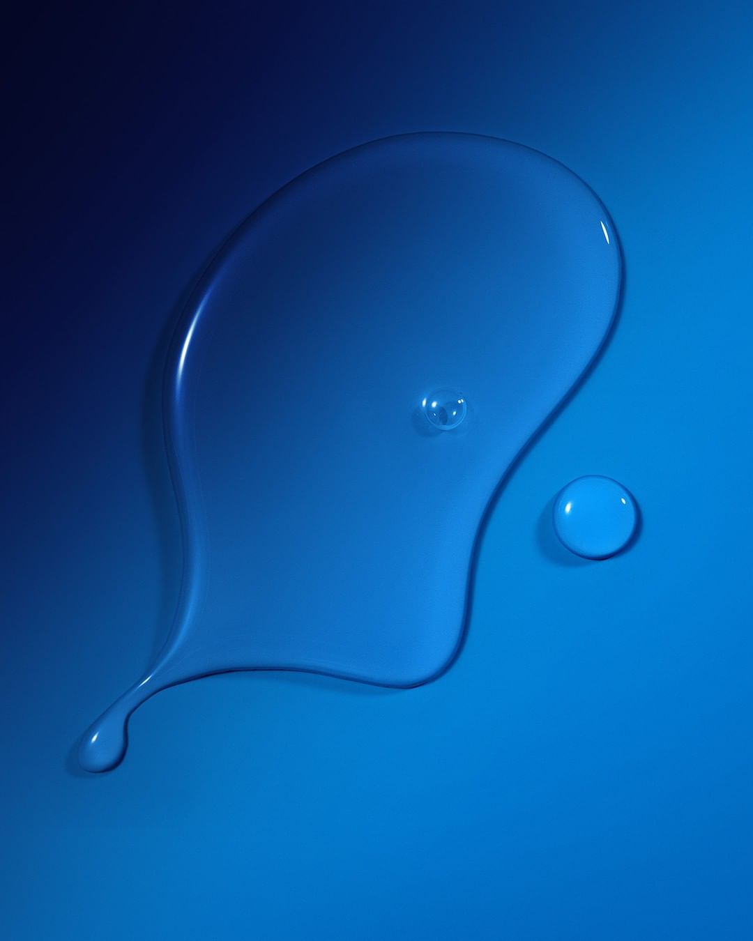 Close-up of a translucent liquid splash with small droplets scattered around against a gradient blue background. Cosmetic concept.