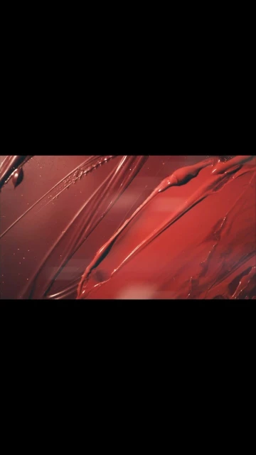 Abstract beauty product advertisement featuring streaks of glossy red and brown lipstick.