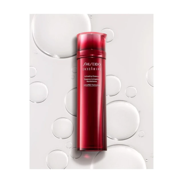 Red bottle of Shiseido Eudermine activating essence on white with water droplets. Beauty product for skincare and cosmetic use.