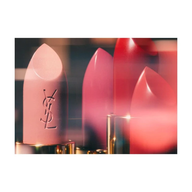Macro shot of three YSL lipstick tubes in pink, red, and rose, featuring the brand logo, showcasing beauty and fashion.