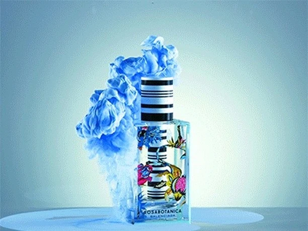 Balenciaga Rosabotanica perfume bottle with a floral design, encircled by soft blue smoke on a light blue surface and background.