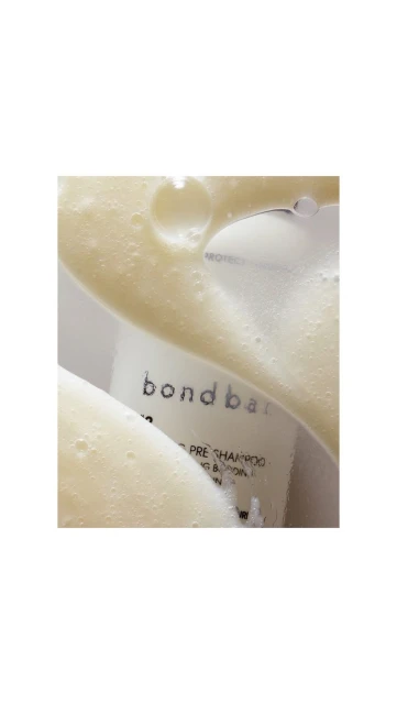 Close-up of Bondbar product with white foamy liquid on top. Beauty product photography. Skin care and hair care advertising.