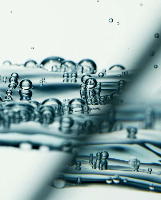 Close-up of water bubbles with a clear, transparent appearance, featuring a narrow depth of field and a soft, diffused light source.