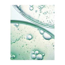 Macro photography of green liquid bubbles and droplets inside glass laboratory petri dishes on white