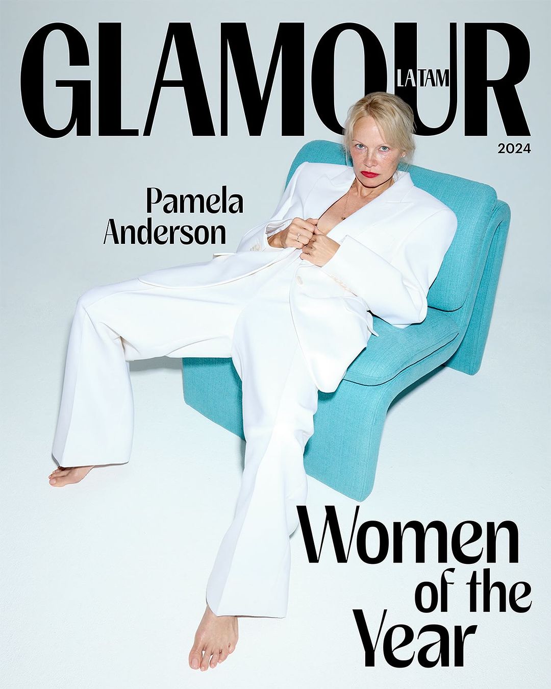 Magazine cover featuring Pamela Anderson in a white suit, seated in a turquoise chair against a clean white background, with 'Glamour' text.