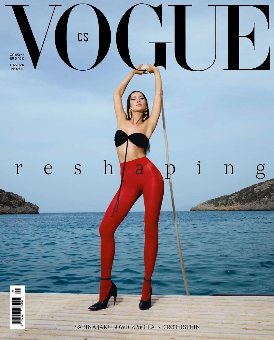 Vogue magazine cover featuring Sabina Jakubowicz in a black bikini top and red leggings, posing outdoors with blue sea background.