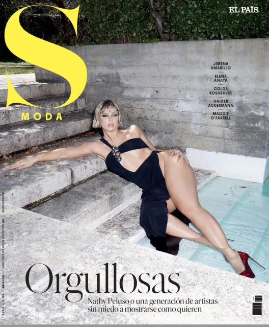Magazine cover featuring a woman in a black one-piece swimsuit with red high heels, reclining on concrete steps near a water feature.