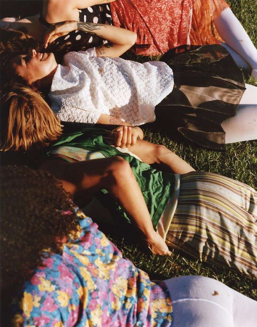 Group of young people lounging together on a sunny patch of grass in New York photographed by Clara Balzary.