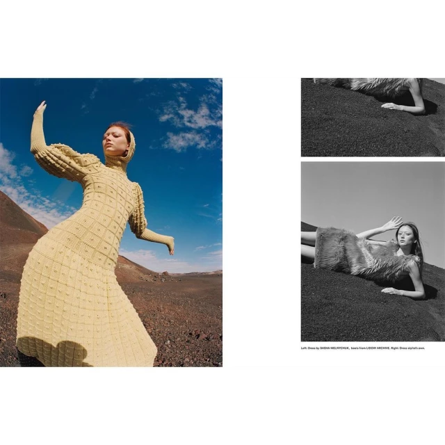 A woman in a light yellow dress with long sleeves and a head covering poses in an open desert landscape under a blue sky.