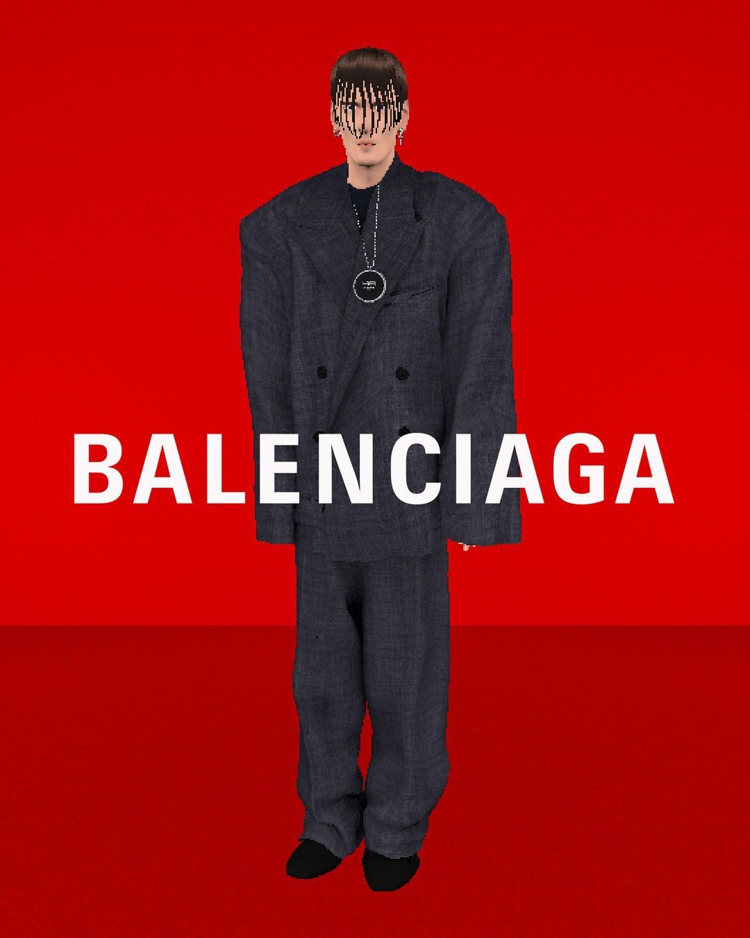 Fashion model in oversized blue suit and black shoes poses against red backdrop with BALENCIAGA logo. Studio lighting, dark hair.