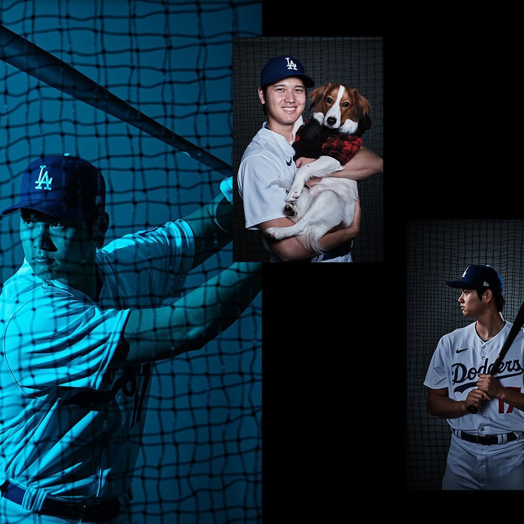 Baseball player Shohei Ohtani in Dodgers uniform, posing with bat and dog. Sports and celebrity, against a dark backdrop.