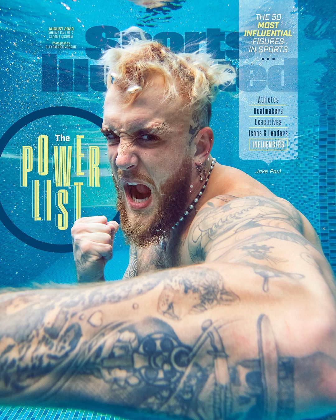 Sports Illustrated magazine cover features Jake Paul underwater; his fist is raised, expression intense; and the magazine's logo is visible.