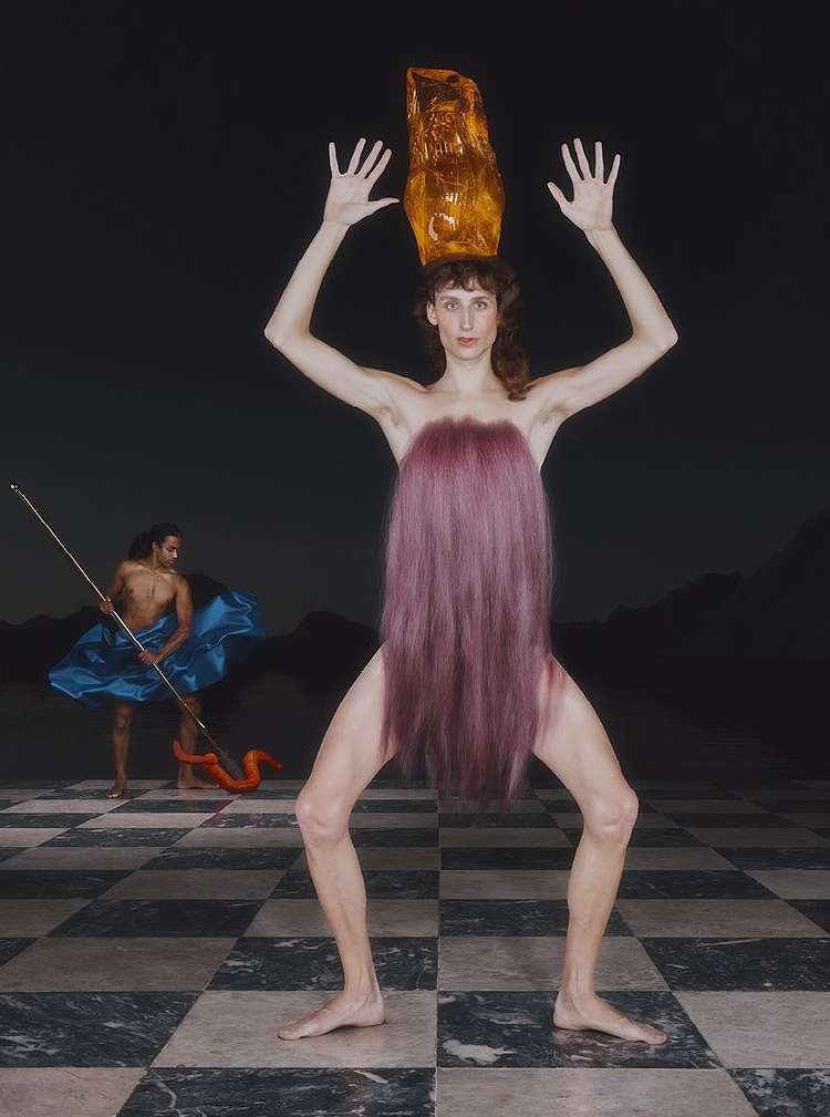 Surreal portrait of a fair-skinned woman with a golden headpiece, standing on a checkered floor with a second figure in the background.