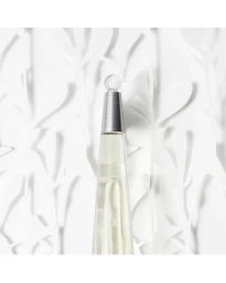Close up of a tall conical perfume bottle with a metallic cap against a textured white paper art background.