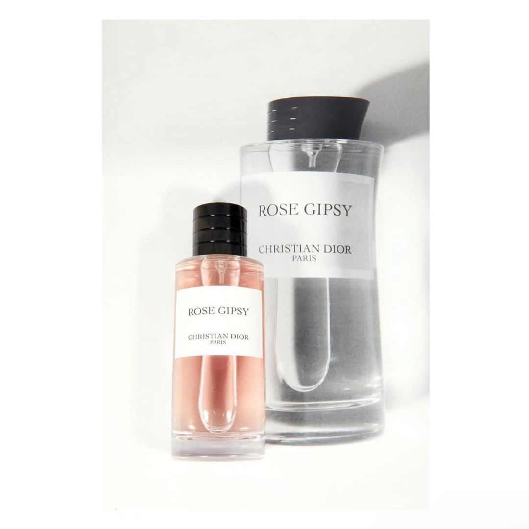 Two clear glass perfume bottles with black caps, labeled 'Rose Gipsy Christian Dior Paris', on a white background. Product photography.