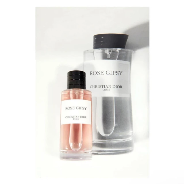 Two clear glass perfume bottles with black caps, labeled 'Rose Gipsy Christian Dior Paris', on a white background. Product photography.