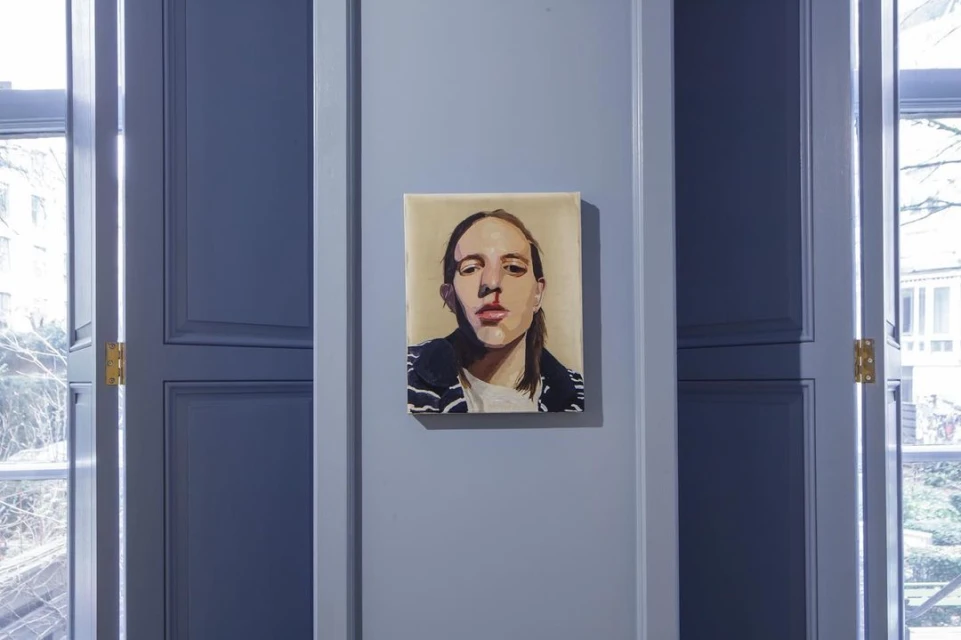 Painted portrait of a young adult with long hair and a striped jacket on a gray wall between two blue paneled doors.