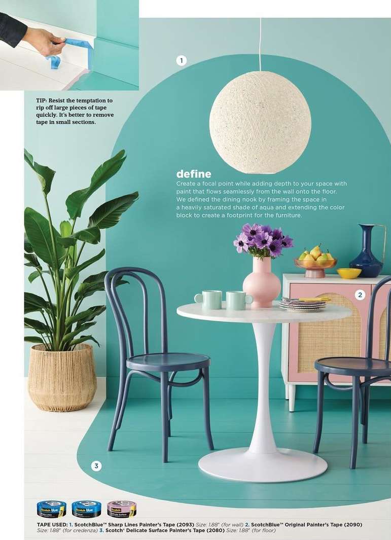Interior design features an aqua wall, a white tulip table with a vase of purple flowers, and blue chairs in a home dining room setting.