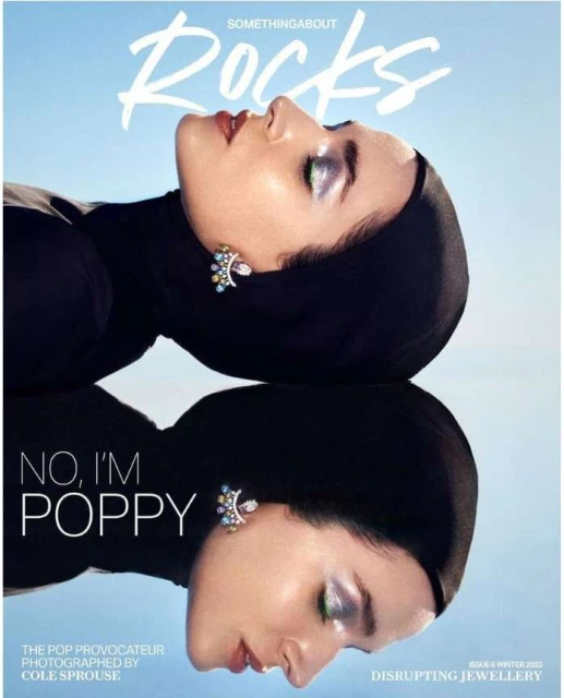 Magazine cover featuring a woman in a black head covering with reflective makeup and jeweled earrings, with a mirrored reflection.