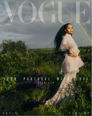 Vogue Portugal cover features a woman in a flowing dress standing in a field with a rainbow in the background, artistic fashion portrait.