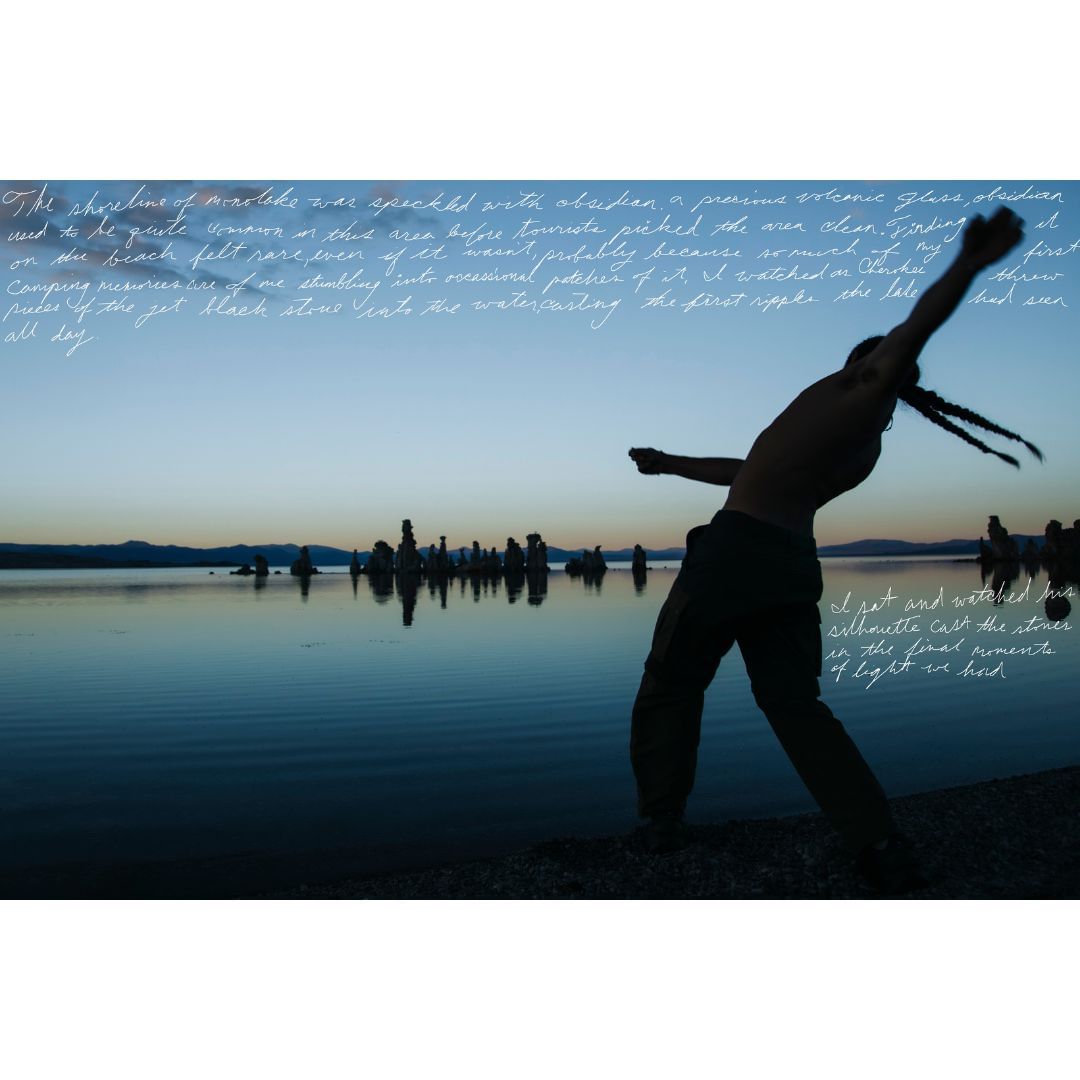Silhouette of shirtless adult male throwing a stone into calm lake at sunset near rock formations; blue and orange hues dominate the scene.