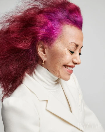 Profile portrait of an elderly woman with bright pink and magenta hair wearing a white turtleneck and blazer by Coliena Rentmeester