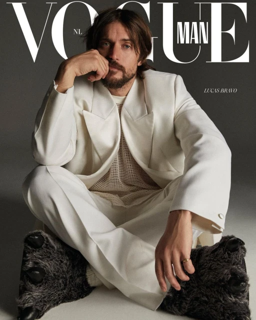 Magazine cover features a male model wearing a white suit and slippers, seated against a gray background with 'Vogue Man' text.