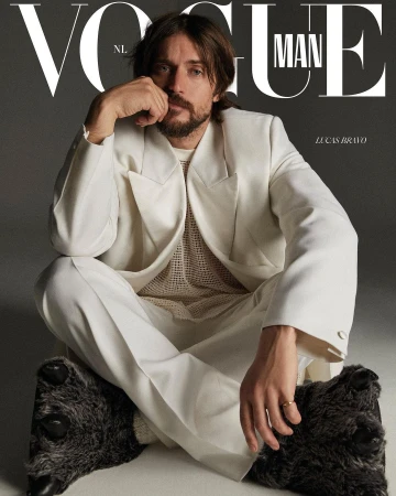 Magazine cover features a male model wearing a white suit and slippers, seated against a gray background with 'Vogue Man' text.