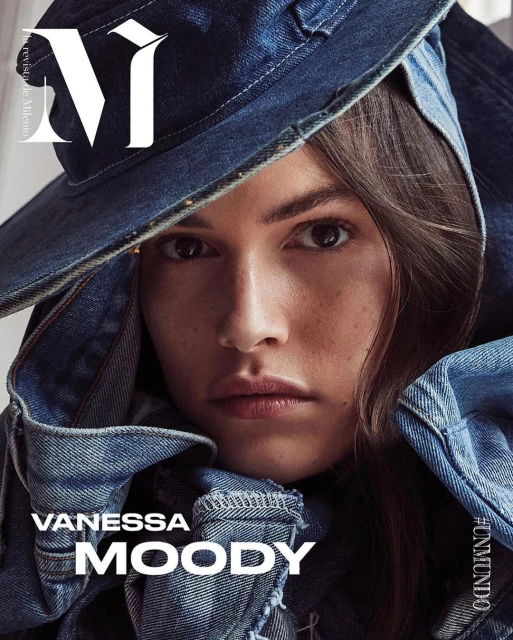 Close-up portrait of Vanessa Moody on a magazine cover, styled in a denim hat and jacket, with a neutral facial expression.