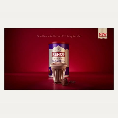 Kenco Millicano Cadbury Mocha instant coffee in a glass with chocolate chunks on a red background with bright studio lighting.