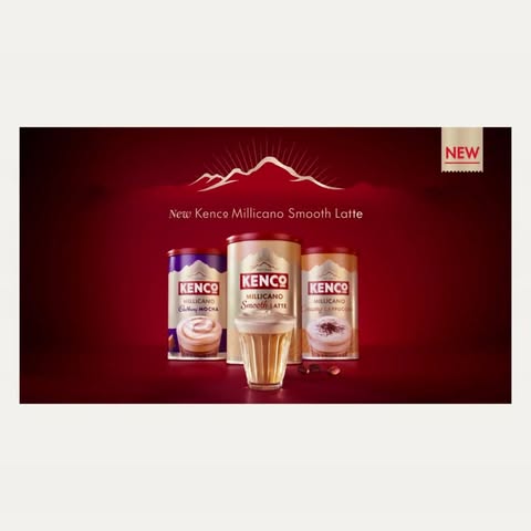Kenco Millicano Smooth Latte cans with a glass of coffee in a studio setting against a dark red background. New product advertisement.