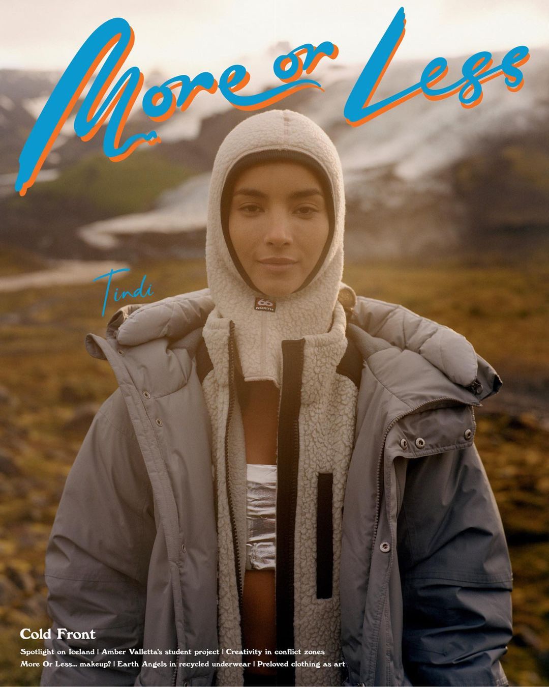 Magazine cover featuring a model in a hooded jacket against a blurred landscape backdrop, promoting a fashion or lifestyle brand.