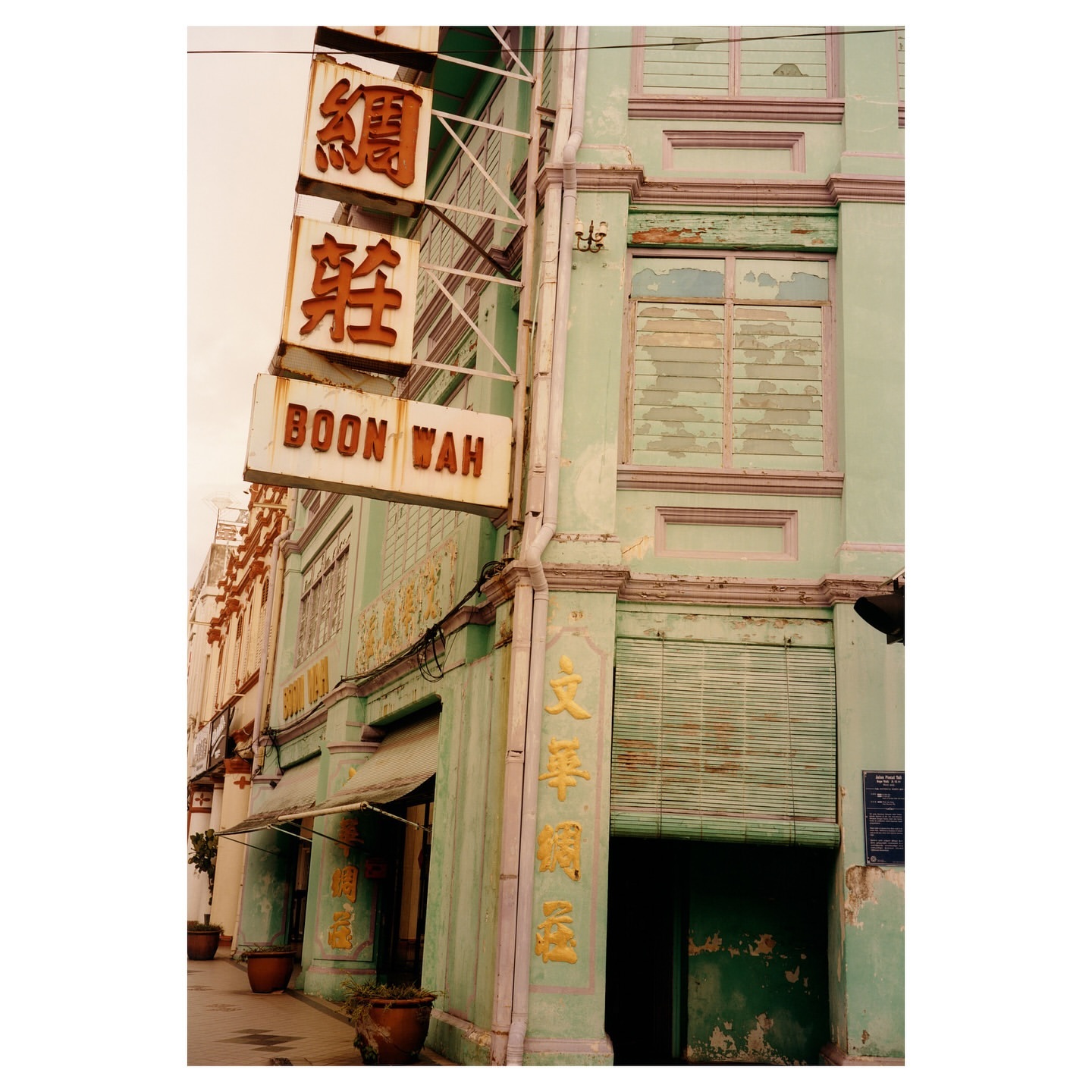 Exterior of a building with a vintage sign displaying Chinese characters and the English name 'Boon Wah', showcasing aged architecture.
