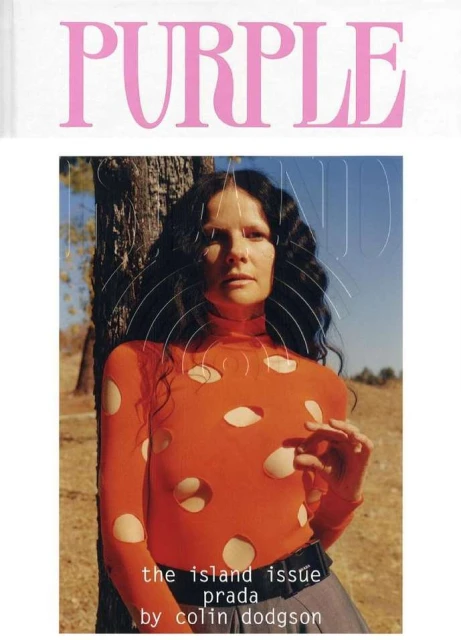 Fashion magazine cover with a woman in an orange long-sleeve top standing outdoors with a tree and sky visible.