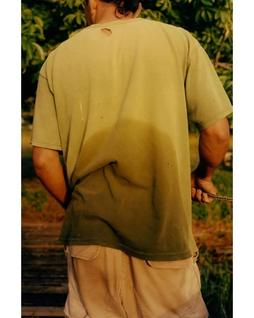 Man from behind wearing a green t-shirt and tan cargo shorts outdoors in New York by photographer Colin Dodgson.
