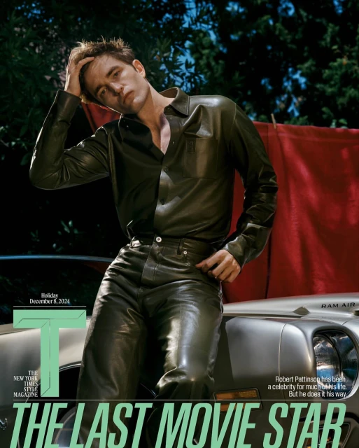 Robert Pattinson in a fashion editorial wearing a leather shirt and pants, leaning against a car. Cover of the New York Times Magazine.
