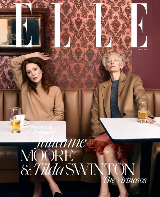 ELLE magazine cover featuring Julianne Moore and Tilda Swinton sitting at a table in a restaurant, medium shot, indoor scene with vintage wallpaper.