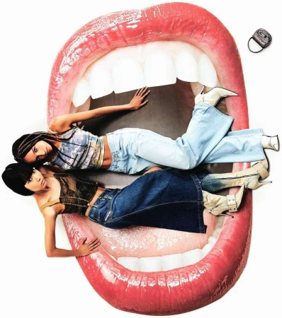 Two women laying in giant mouth wearing denim and white boots in a collage style fashion shot with white background and small purse floating.