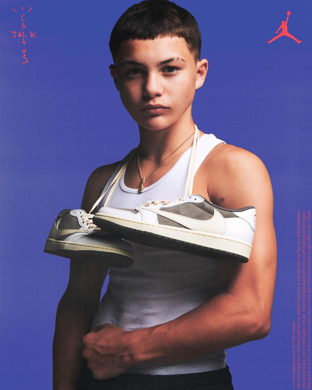 Teenager poses with sneakers in a studio shot, featuring a stylish tank top and a vibrant blue backdrop with Jordan and Cactus Jack branding.