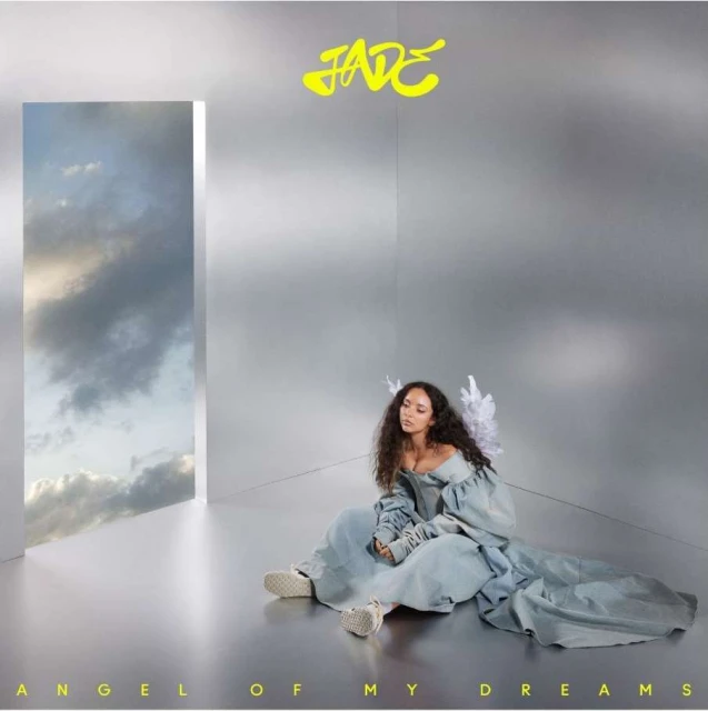 Young woman with angel wings sits gracefully in an ethereal setting, complemented by a window view of cloudy skies, in a light and airy scene.