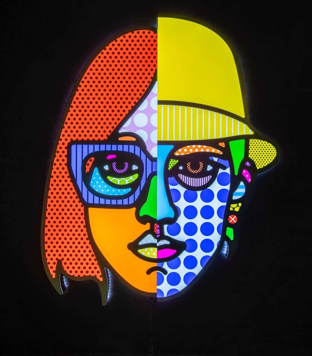 Pop art split face illustration by Craig and Karl featuring vibrant primary colors, polka dots, and graphic patterns on a black background